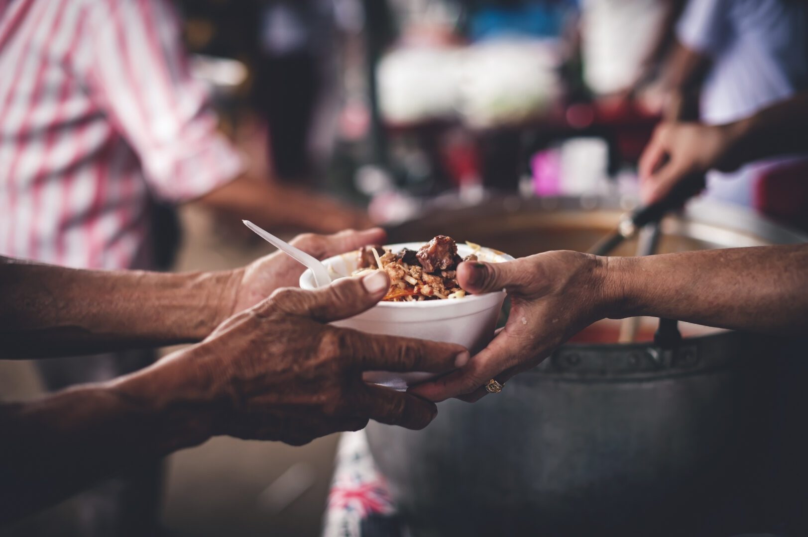 concept-of-giving-free-food-to-the-poor-in-the-community-volunteers-handing-out-food-to-hungry-people